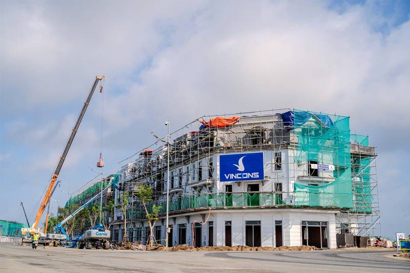 Ảnh thật dãy nhà phố tại Vinhomes Green Paradise đang hoàn thiện mặt ngoài, cẩu và băng rôn nhà thầu Vincons